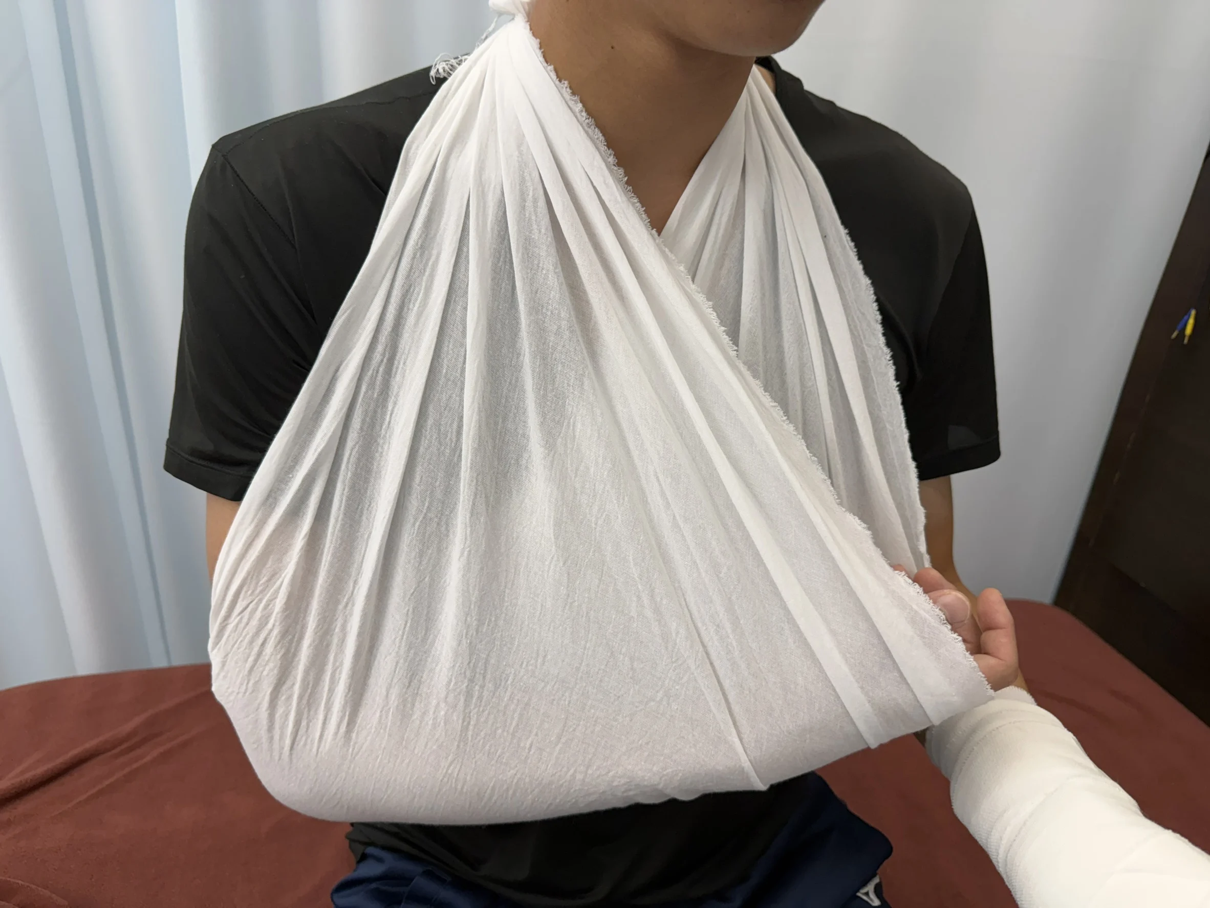 三角巾で腕を支持している様子
